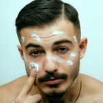Mann über 35 bei der täglichen Gesichtspflege im Badezimmer
