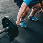 Mann über 40 beim klassischen Krafttraining mit Langhantel im Fitnessstudio