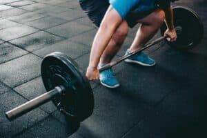 Mann über 40 beim klassischen Krafttraining mit Langhantel im Fitnessstudio
