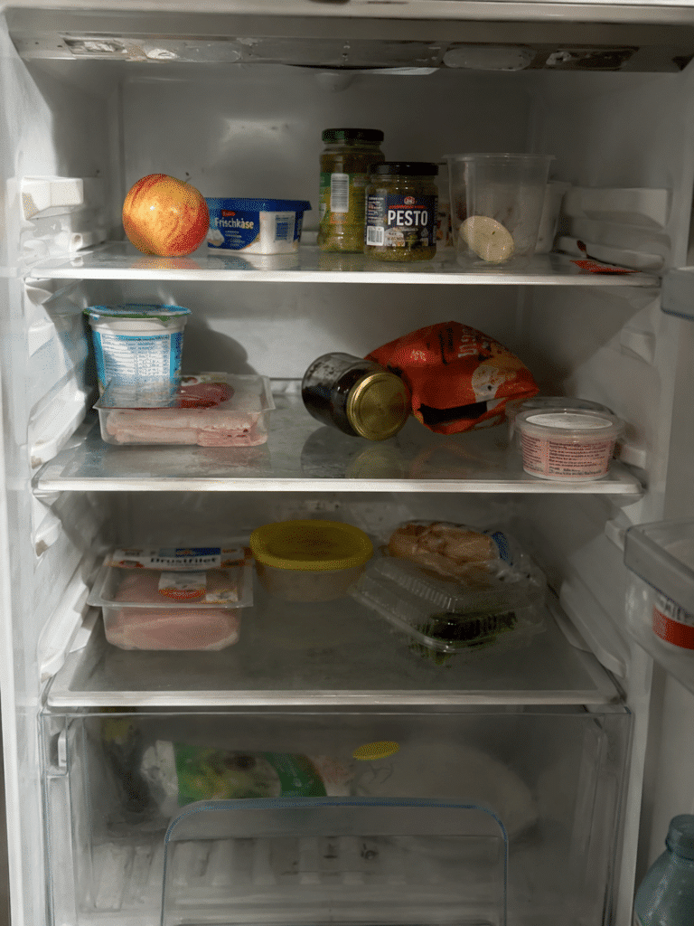 Meal Prep Ideen — leerer unorganisierter Kühlschrank vor dem Meal Prep
Bildprompt