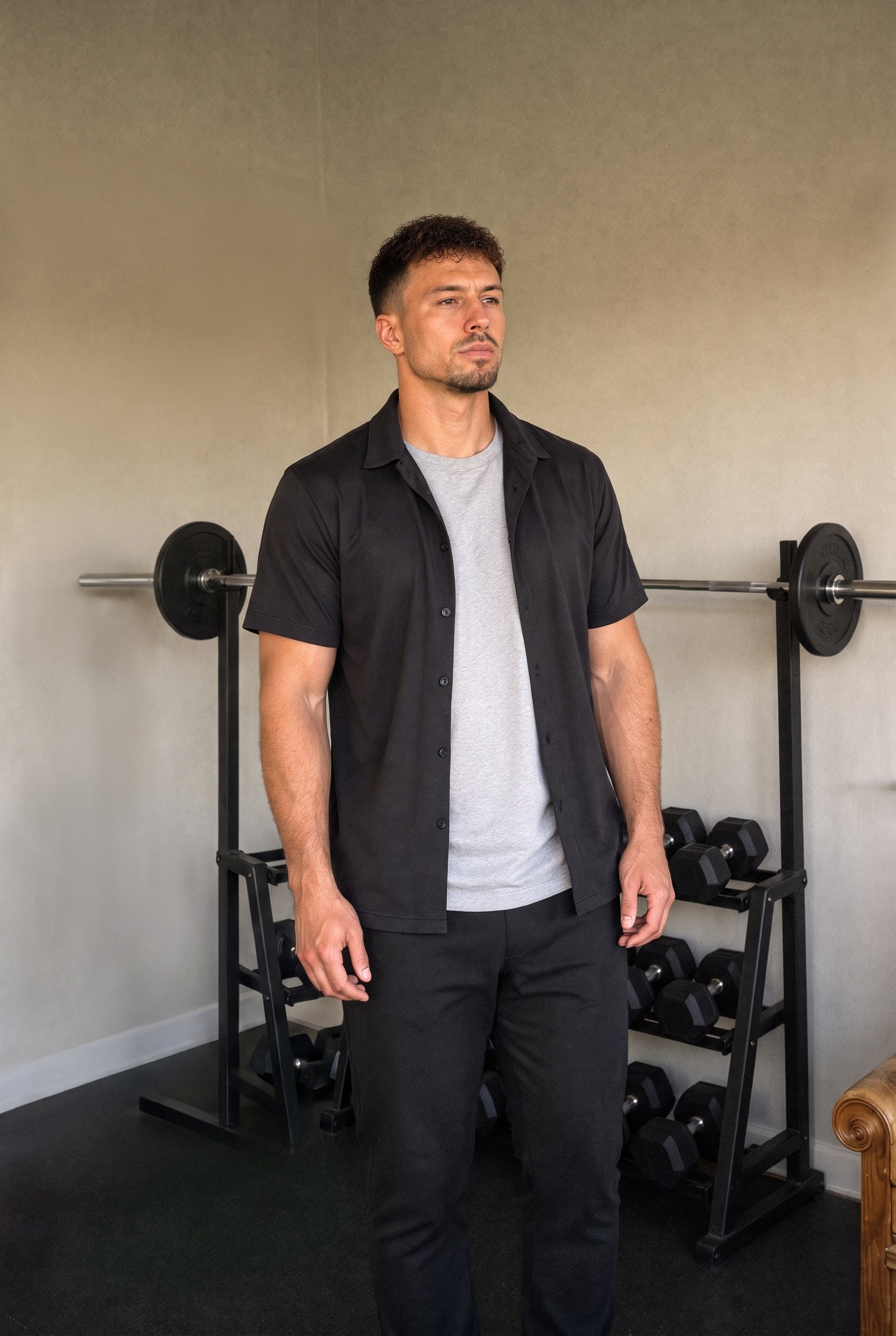 Fabian Waizenhöfer im Home-Gym in Graubünden, entspannte Haltung vor Langhantel-Rack