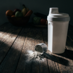 Whey Protein Test Vergleich 2026 – Shaker und Pulver auf dunklem Holztisch